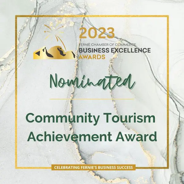 A gold and white award with the words " nominated community tourism achievement award ".