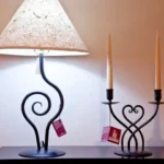 A table with two lamps and one candle holder.