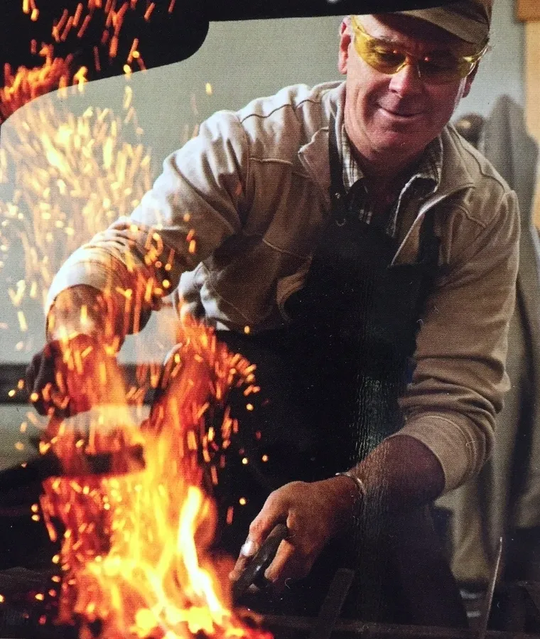 A man holding an object in front of fire.