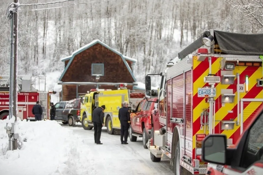 A fire truck and other vehicles parked in the snow.