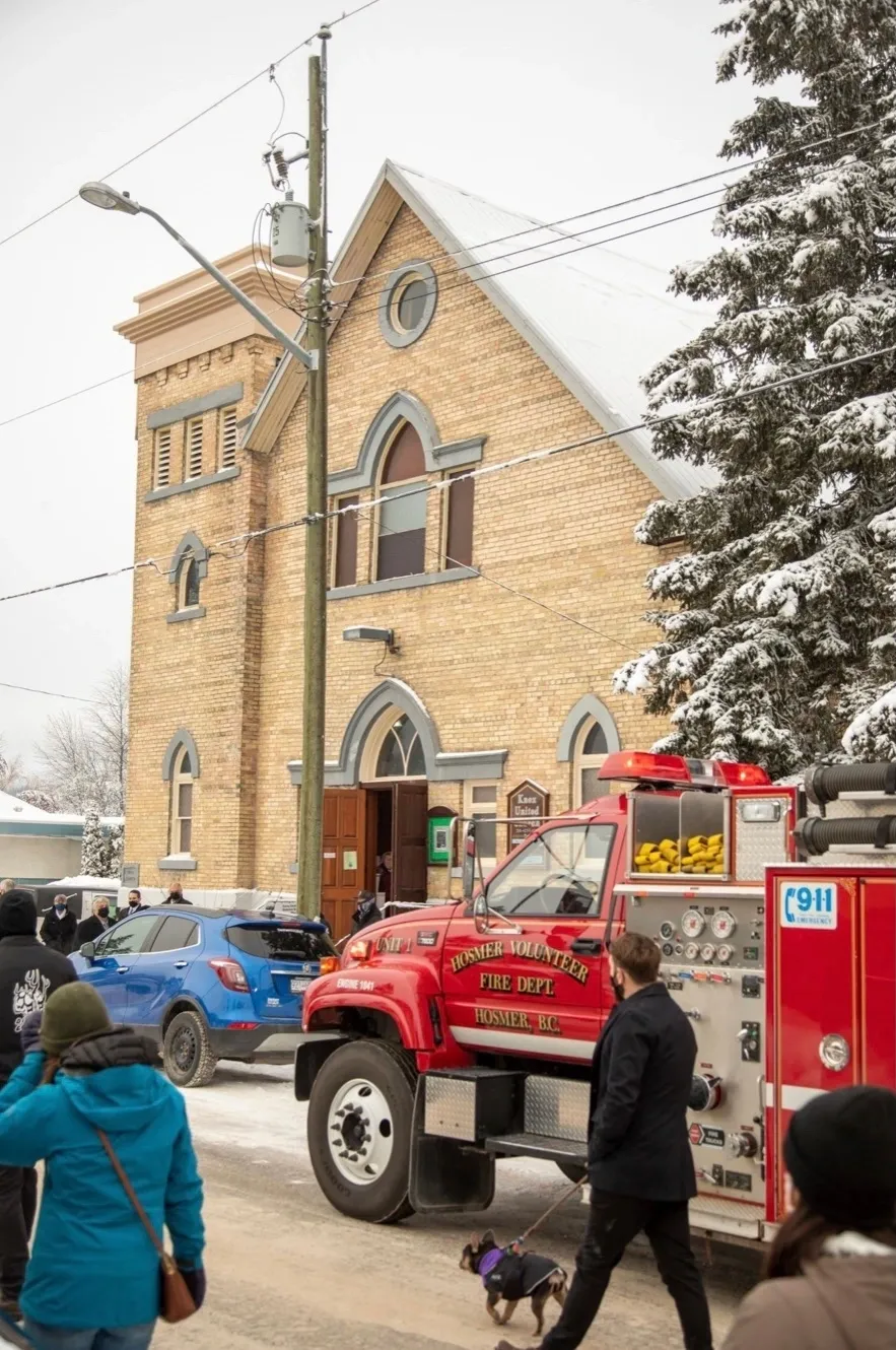 A fire truck parked in front of a church.