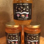 Three jars of honey on a table.