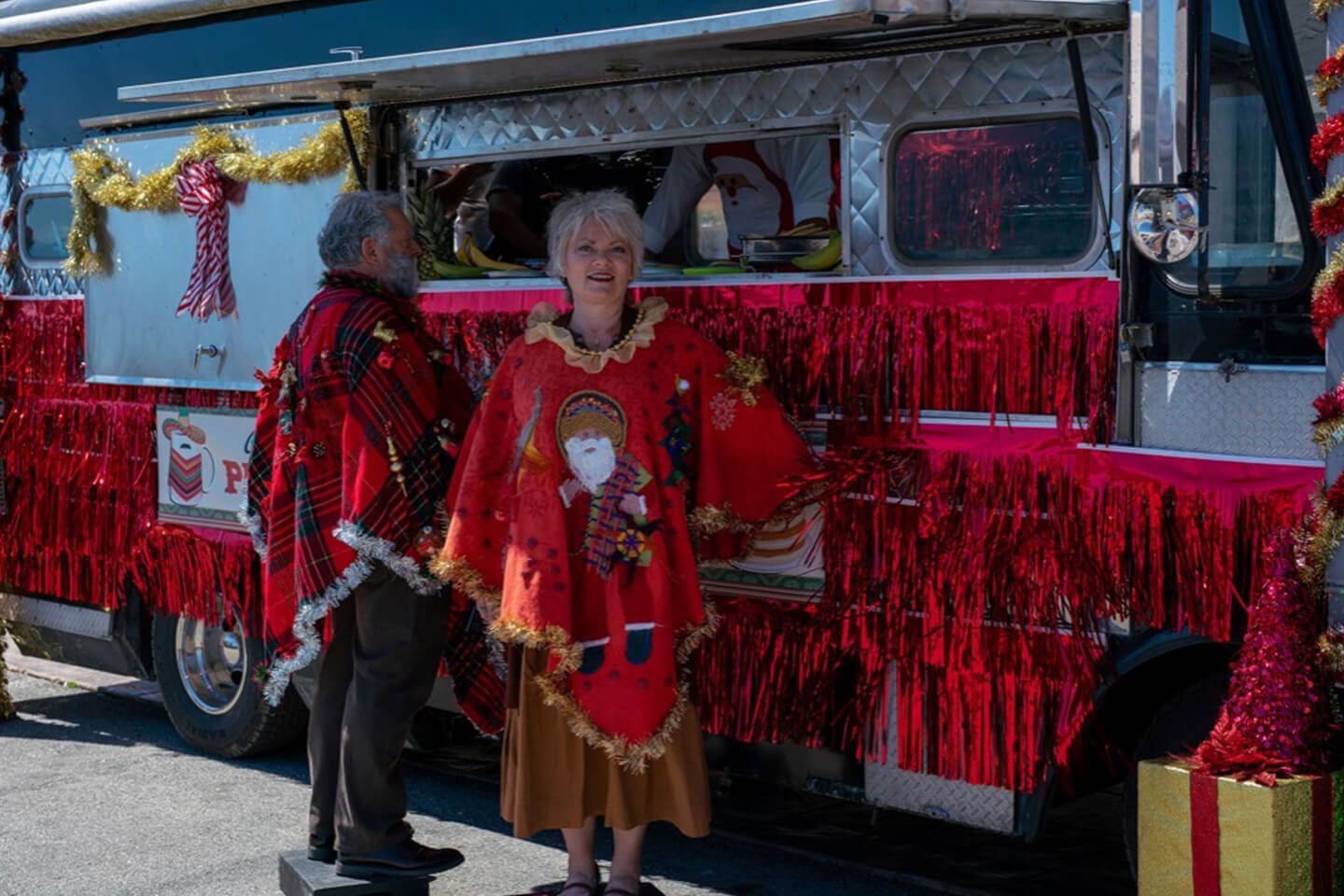 A woman in costume standing next to a red van.