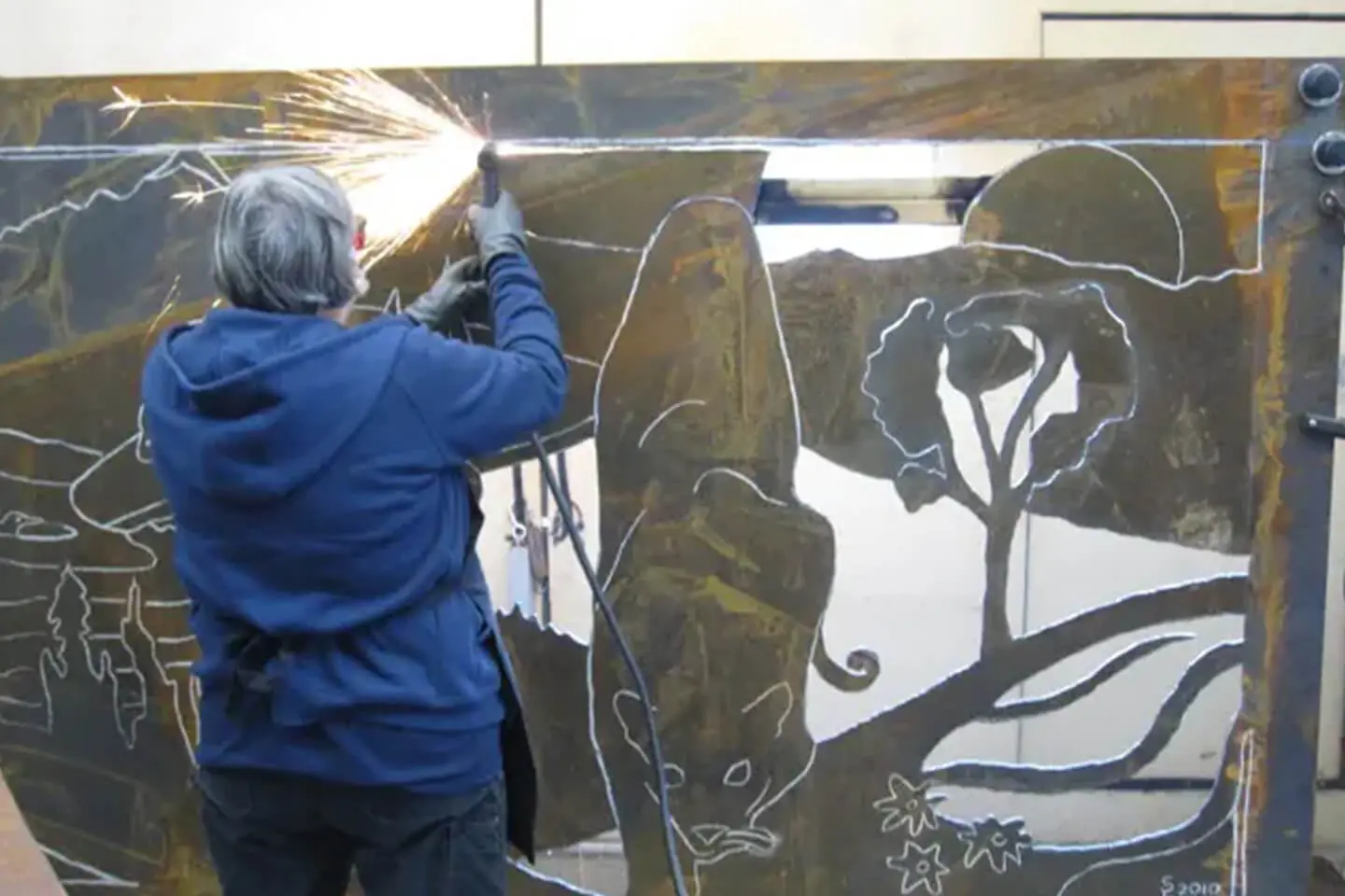 A person working on a painting of animals.