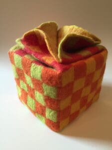 A small cube with a yellow and red checkered pattern.
