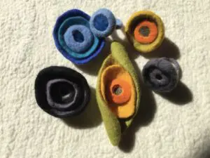 A group of colorful felt objects on top of a white surface.